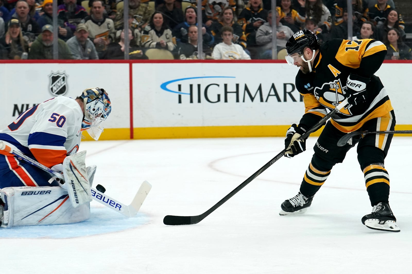 New York Islanders goaltender Marcus Hogberg (50) makes a save against Pittsburgh Penguins' Bryan Rust (17) during the second period of an NHL hockey game Sunday, Dec. 29, 2024, in Pittsburgh. (AP Photo/Matt Freed)