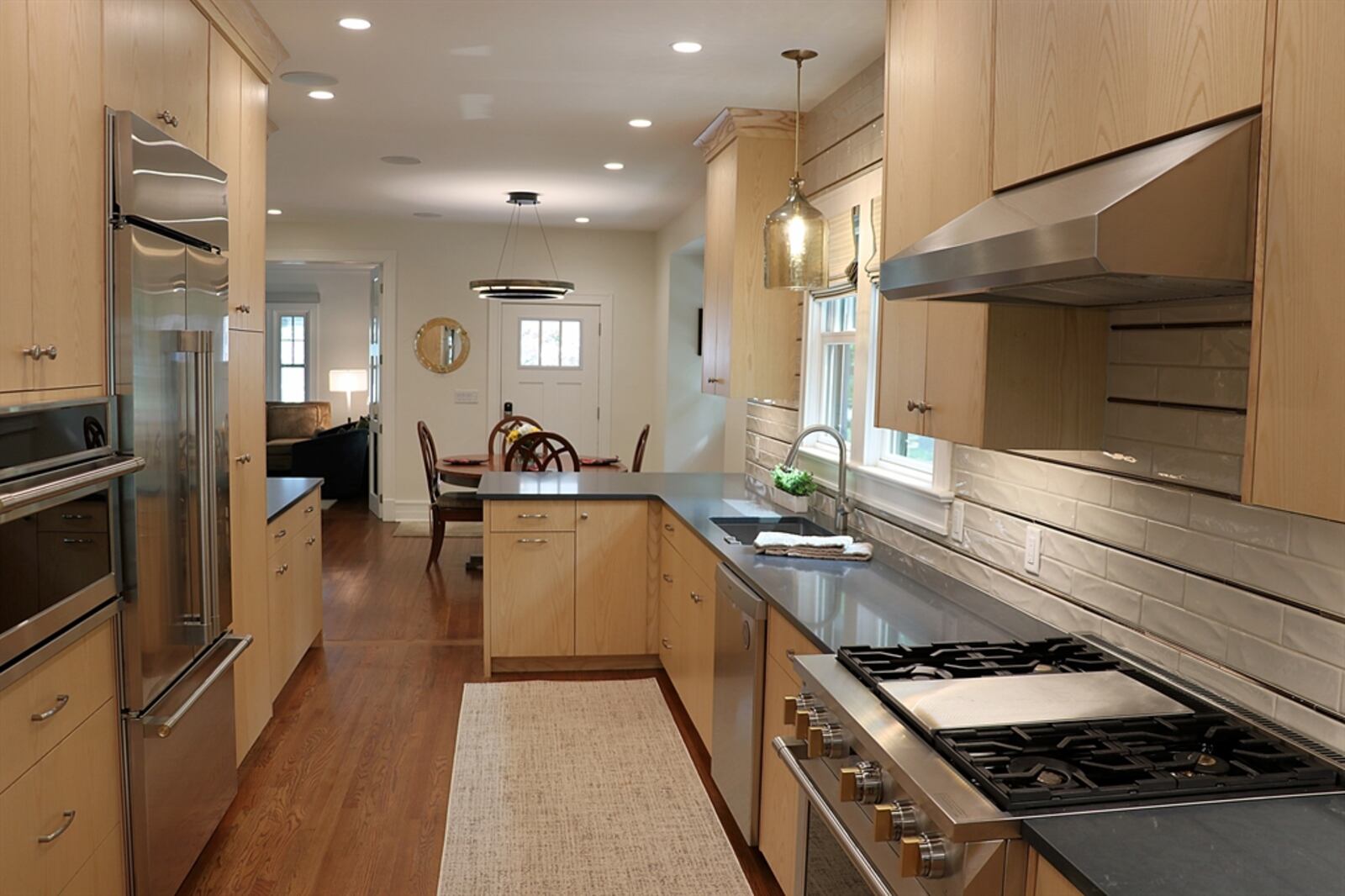 Light wood custom cabinetry lines two walls, creating a galley-style kitchen.