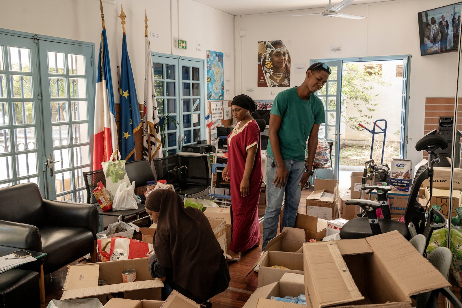 Volunteers sort through donations for victims of cyclone Chido in Mayotte at the House of Mayotte, in Saint-Denis, Réunion Island, Wednesday, Dec. 18, 2024. (AP Photo/Adrienne Surprenant)