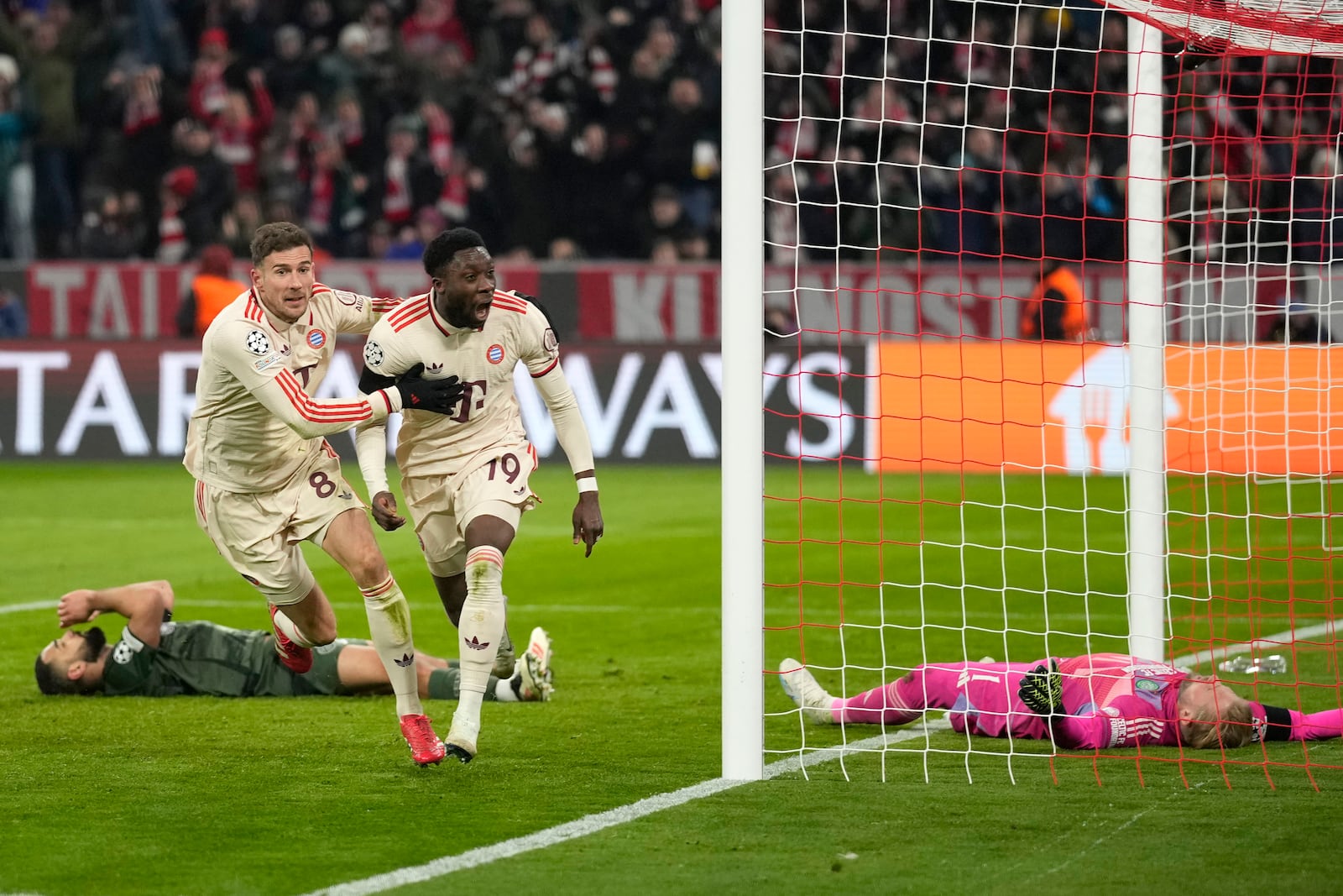 Bayern's Alphonso Davies, centre, celebrates after scoring his side's opening goal during the Champions League playoff second leg soccer match between FC Bayern Munich and Celtic Glasgow at the Allianz Arena in Munich, Germany, Tuesday, Feb. 18, 2025. (AP Photo/Matthias Schrader)