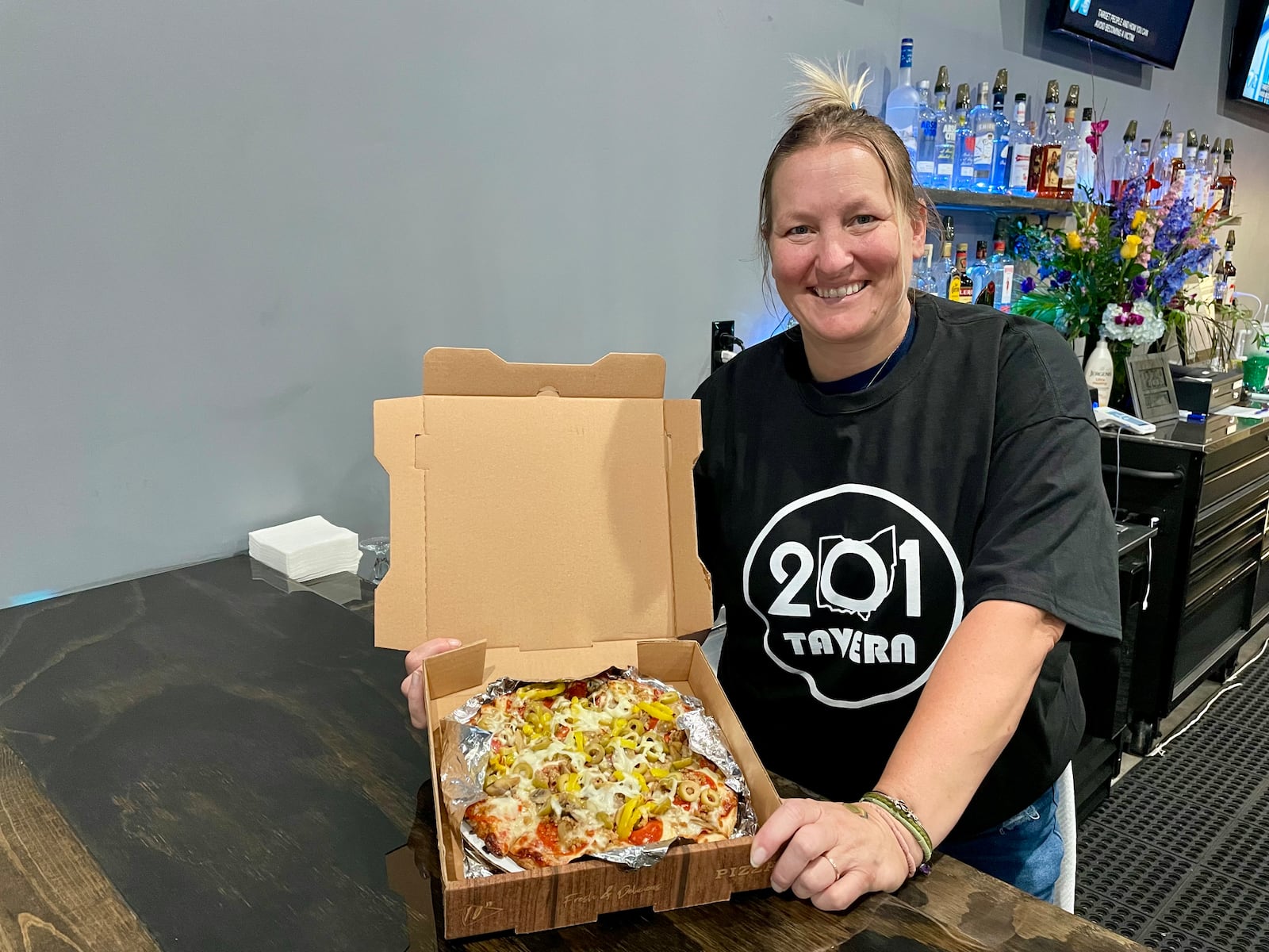 201 Tavern, a new restaurant serving pizza, subs and more, has opened in the former spot of Paisano’s Pizza Pub in the Old North Dayton neighborhood. Pictured is Christine Fowler, who owns the tavern with her husband, Shante. NATALIE JONES/STAFF