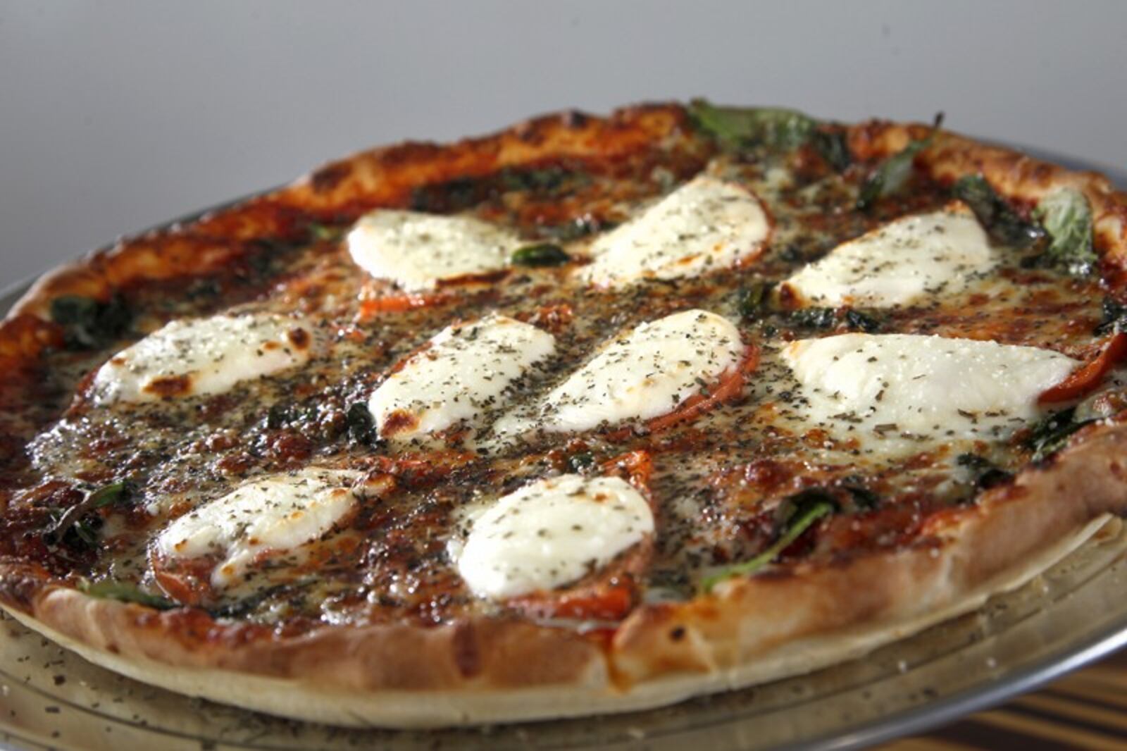 Gionino's Pizzeria makes a 'Caprese pizza' with signature pizza sauce on a thin crust with fresh mozzerella and provolone cheese, spinach, basin , tomatoes and parmesan cheese. The pizzeria opened its first Dayton location at 1528 E. Third St. The franchise, owned by Tony Clark, has about 45 locations between Cleveland and Canton, with a Columbus location as well. LISA POWELL / STAFF