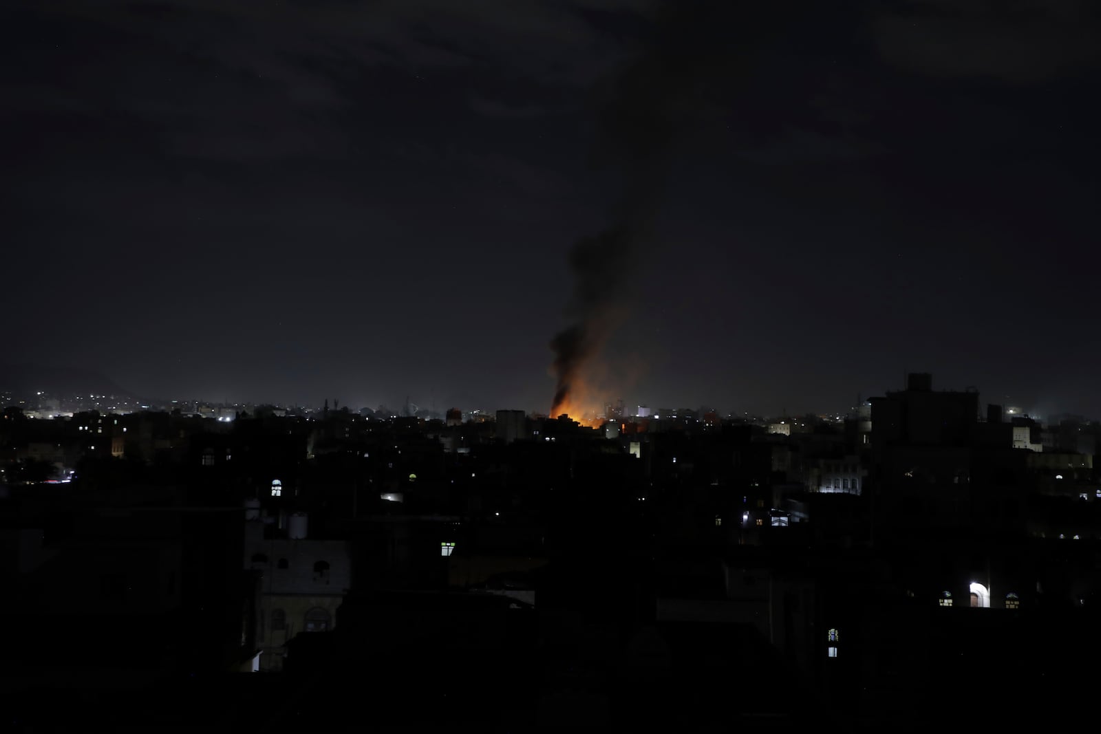 Smoke rises from a location reportedly struck by U.S. airstrikes in Sanaa, Yemen, Wednesday, March 19, 2025. (AP Photo/Osamah Abdulrahman)