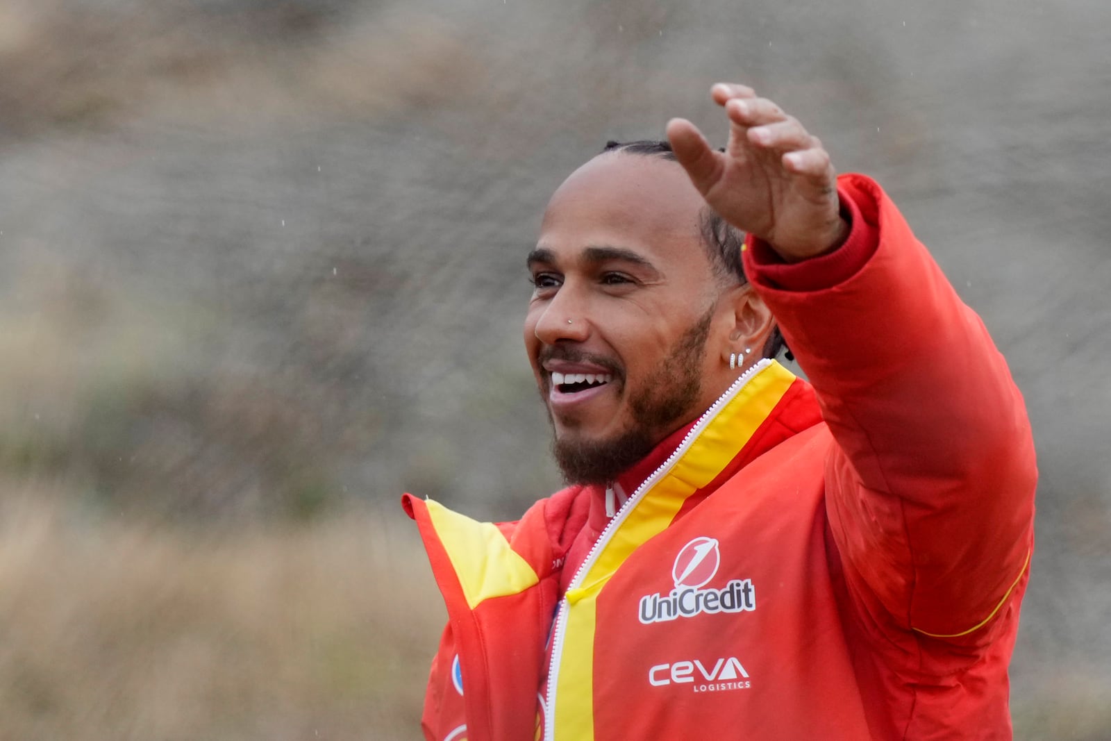 British driver Lewis Hamilton cheers Ferrari fans gathered outside the track, after testing a Ferrari Formula One SF-23, in Fiorano Modenese, Italy, Wednesday, Jan.22, 2025. (AP Photo/Luca Bruno)