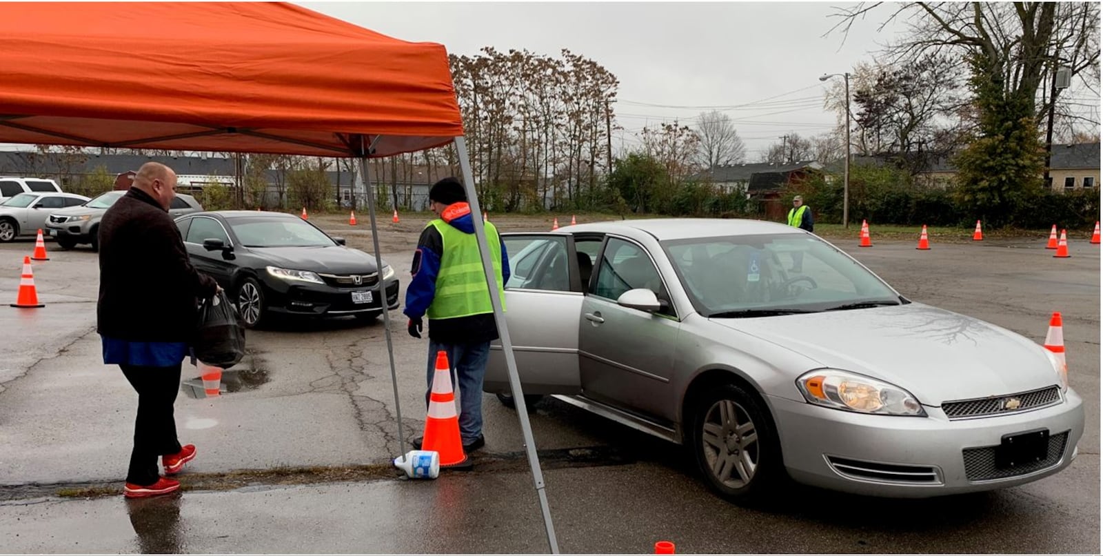 Volunteers at Evangel Church of God bring Thanksgiving to-go meals to waiting cars on Thursday. The church has hosted a Thanksgiving lunch for more than a dozen years to help those in need in the community. ED RICHTER/STAFF