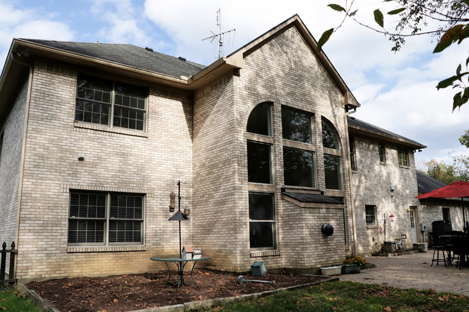 A wall of windows surrounds a gas fireplace within the 2-story great room. The windows allow for the tree-lined back yard to create a natural backdrop to the room. Access to the paver-brick patio is through patio doors from the breakfast room, which is part of the recently renovated kitchen. CONTRIBUTED PHOTO BY KATHY TYLER