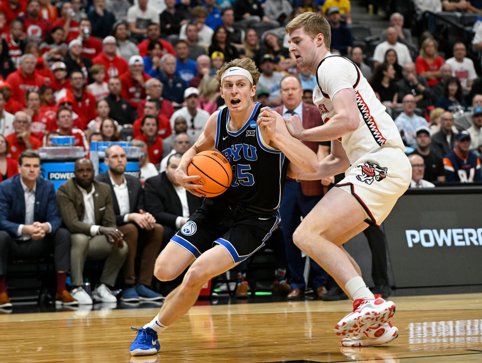 Brigham Young forward Richie Saunders, left, drives past Wisconsin forward Steven Crowl during the first half in the second round of the NCAA college basketball tournament Saturday, March 22, 2025, in Denver. (AP Photo/John Leyba)