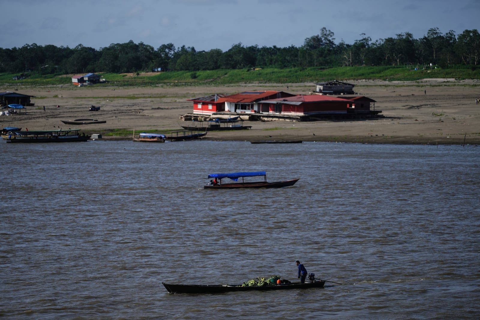 Boats maneuver low water levels amid a drought on the Amazon River, at a port that connects Colombia with Peru, in Leticia, Colombia, Sunday, Oct. 20, 2024. (AP Photo/Ivan Valencia)