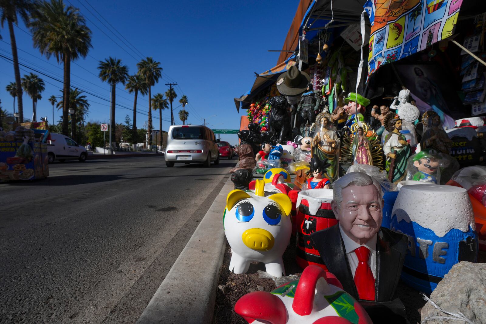 A ceramic statue depicting Mexico's former President Andres Manuel Lopez Obrador is displayed for sale among a variety of figurines at a roadside curios shop in Mexicali, Mexico, Saturday, Feb. 1, 2025. (AP Photo/Fernando Llano)