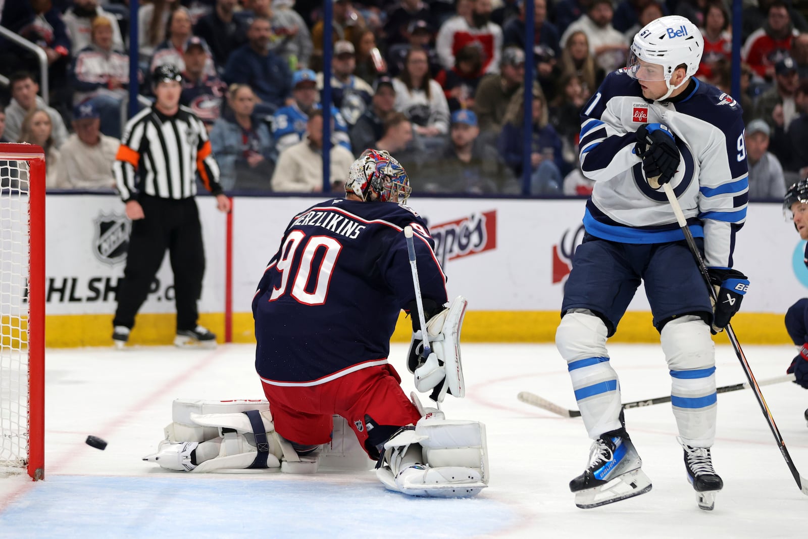 Winnipeg Jets forward Cole Perfetti, right, watches a goal by teammate forward Nikolaj Ehlers past Columbus Blue Jackets goalie Elvis Merzlikins during the first period of an NHL hockey game in Columbus, Ohio, Friday, Nov. 1, 2024. (AP Photo/Paul Vernon)