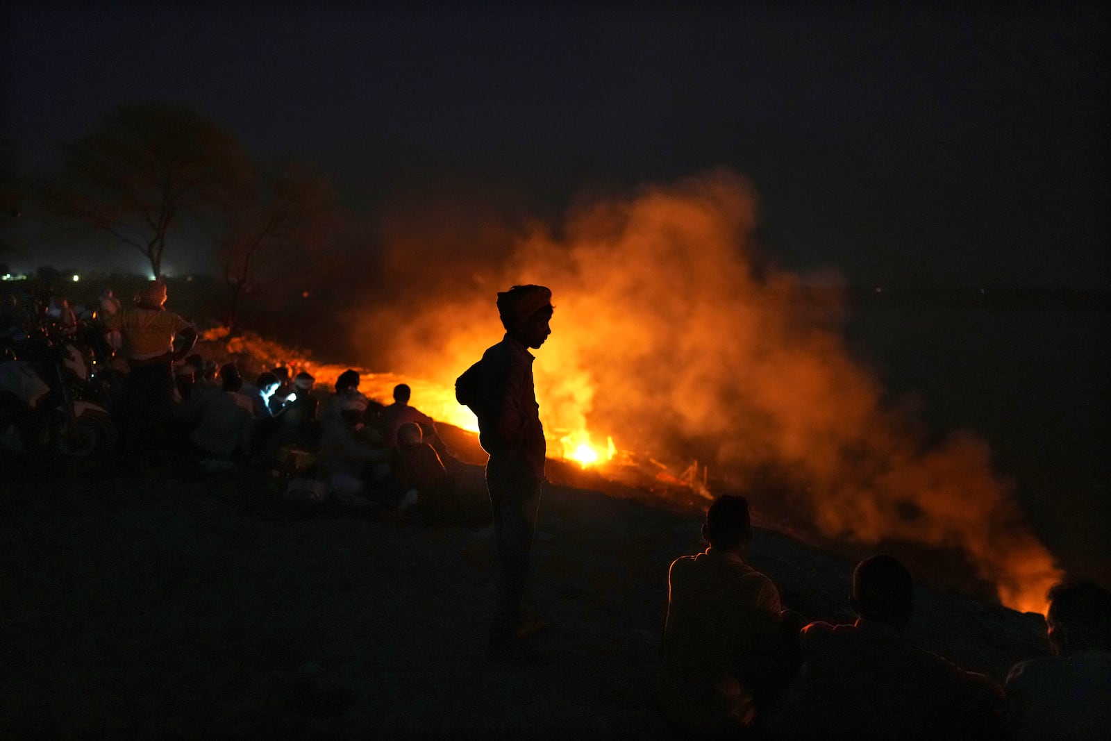 FILE- People cremate their relatives who have died from heat-related illnesses, in Ballia, northern Indian state of Uttar Pradesh, on June 19, 2023. (AP Photo/Rajesh Kumar Singh, File)