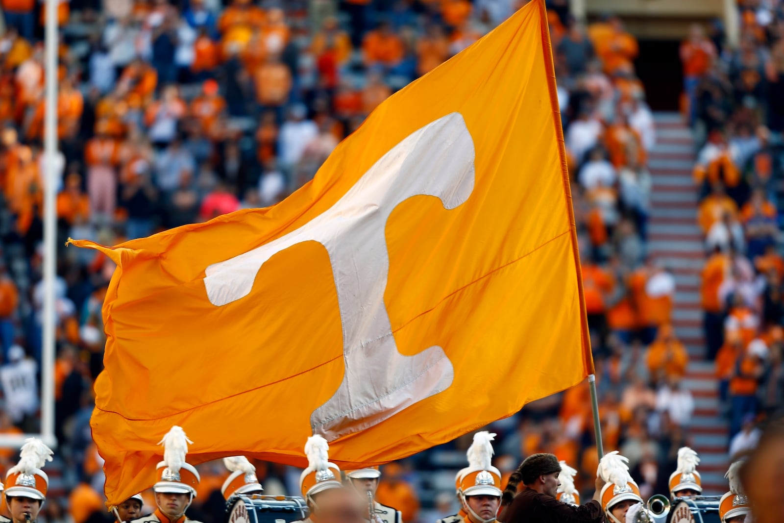 FILE - A Tennessee cheerleader runs with a flag before an NCAA college football game against Vanderbilt, Nov. 25, 2017, in Knoxville, Tenn. (AP Photo/Wade Payne, File)