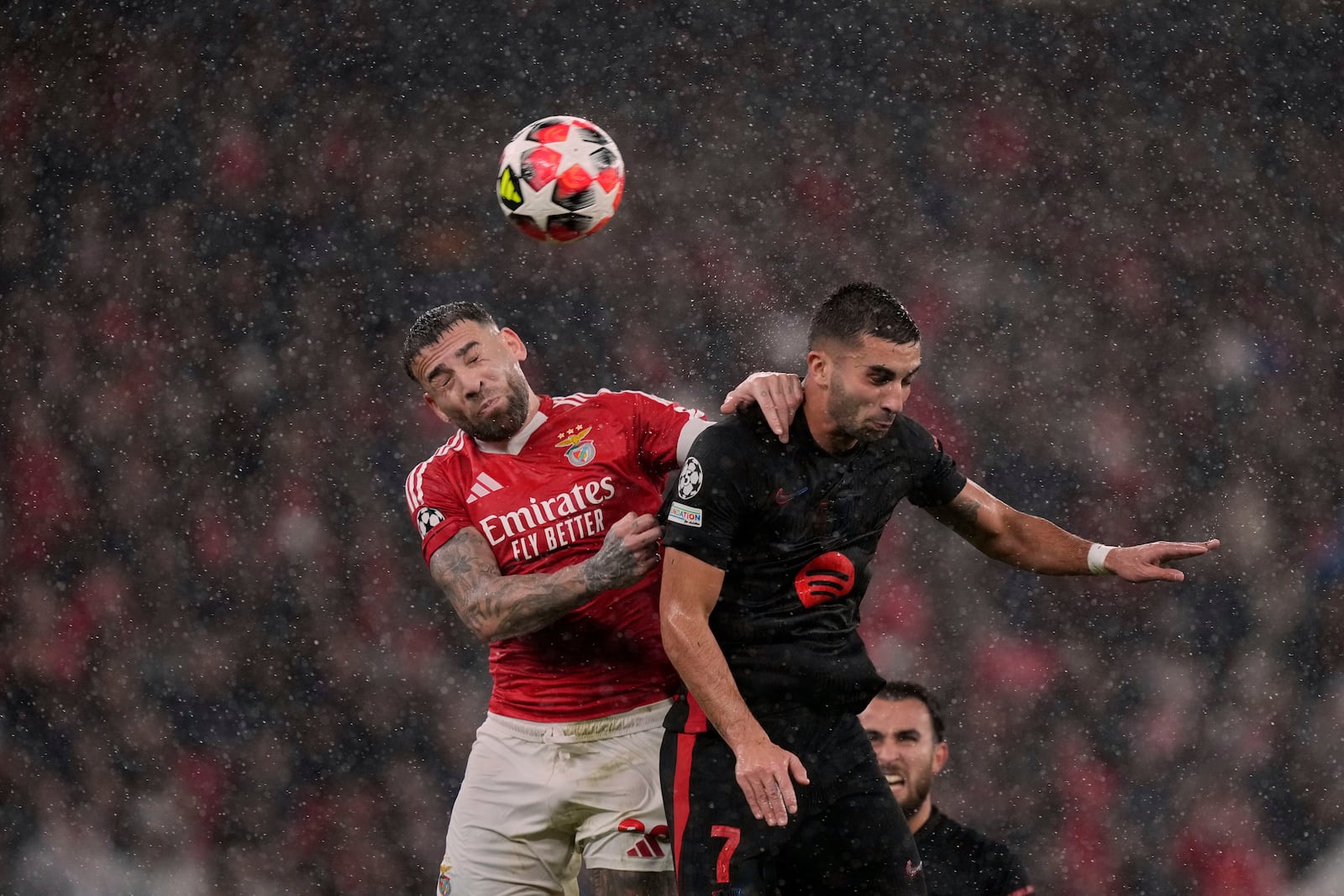 Benfica's Nicolas Otamendi jumps for the ball against Barcelona's Ferran Torres during a Champions League opening phase soccer match between SL Benfica and FC Barcelona at the Luz stadium in Lisbon, Tuesday, Jan. 21, 2025. (AP Photo/Armando Franca)