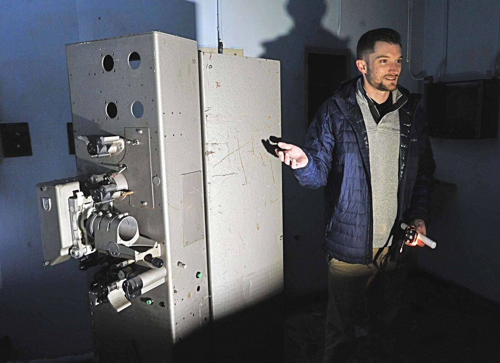 Nonprofit group Fairborn Phoenix hopes to reopen the Fairborn Theater on Broad Street downtown. Chris Morse stands here with the building’s original projector. STAFF/MARSHALL GORBY