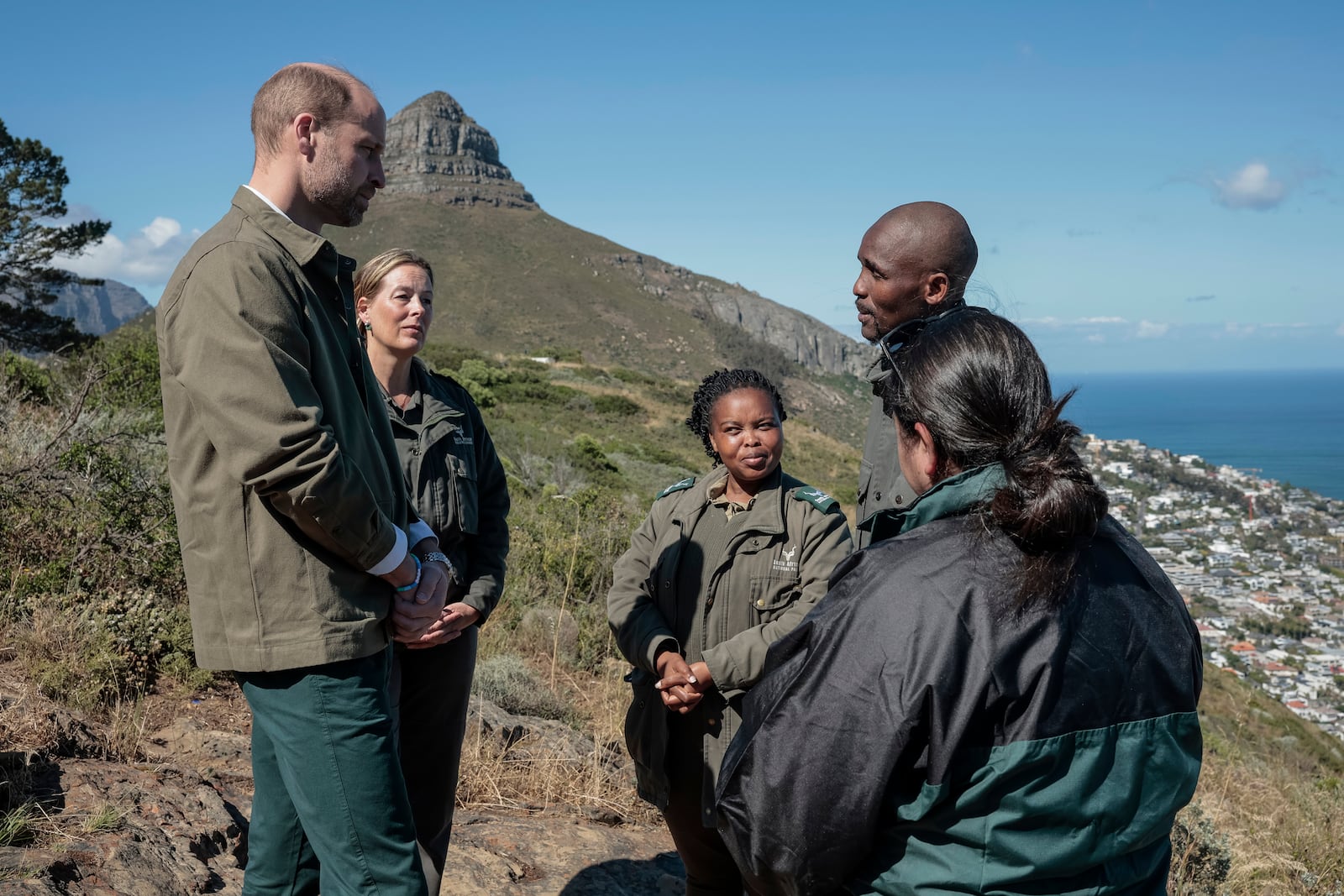 Britain's Prince William, left, meets with Park Manager for Table Mountain National Park Megan Taplin, second left, and other rangers while visiting Signal Hill in Cape Town, South Africa, Tuesday, Nov. 5, 2024. (Gianluigi Guercia/Pool via AP)