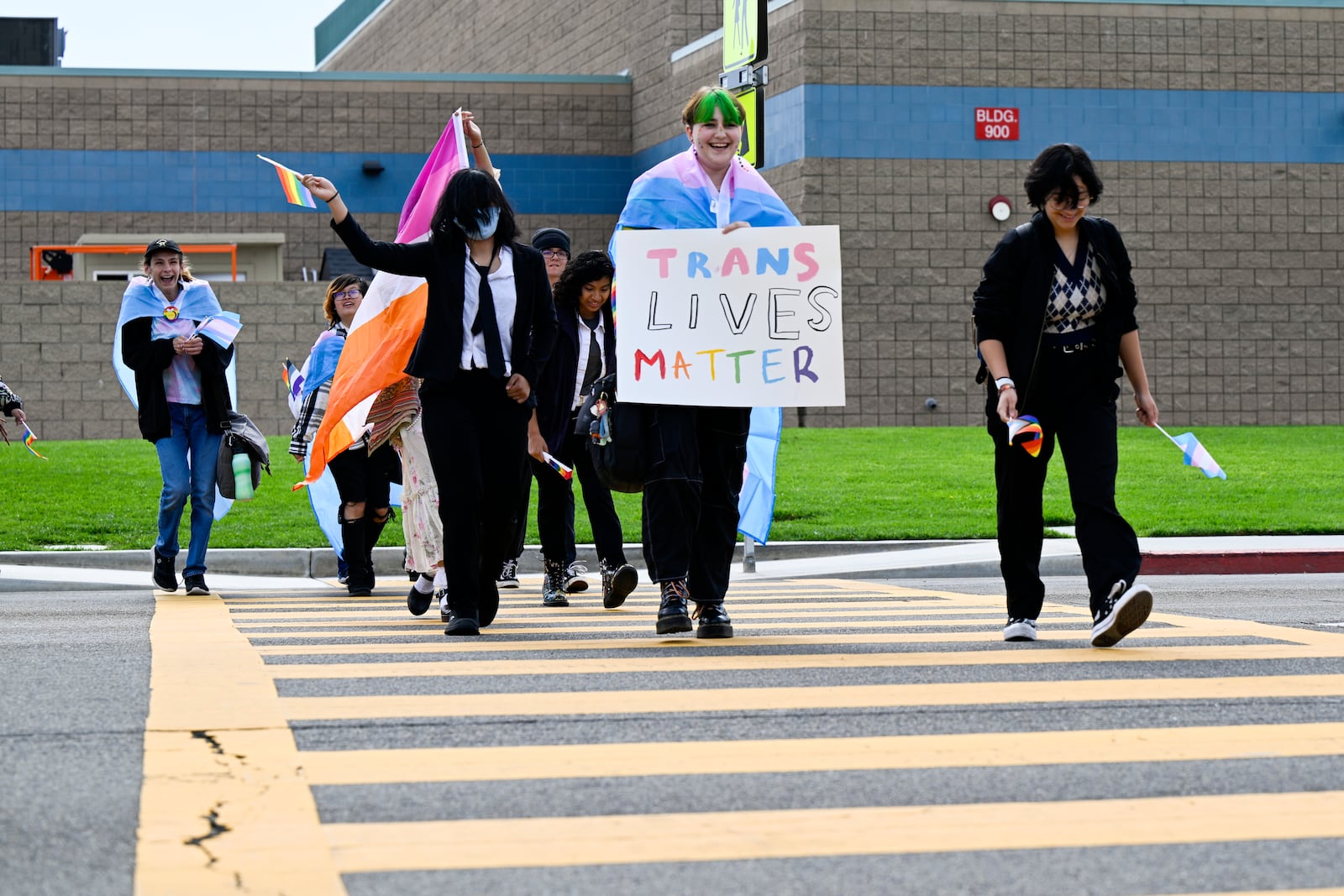 FILE - Students carrying pride and transgender flags leave Great Oak High School in Temecula, Calif., Friday, Sept. 22, 2023, after walking out of the school in protest of the Temecula school district policy requiring parents to be notified if their child identifies as transgender. (Anjali Sharif-Paul/The Orange County Register via AP, File)