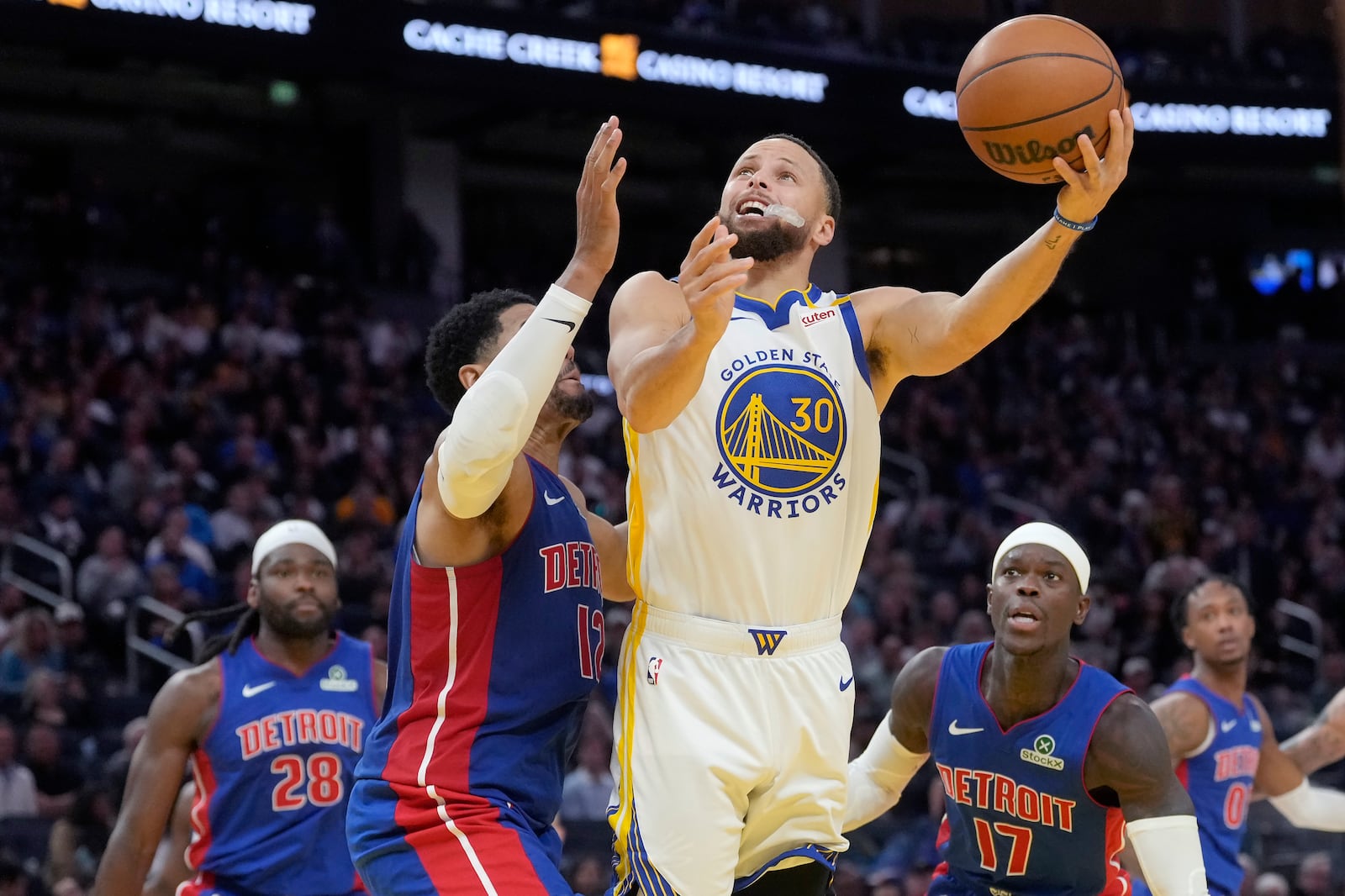 Golden State Warriors guard Stephen Curry (30) goes up to score against Detroit Pistons center Isaiah Stewart (28), forward Tobias Harris, second from left, and guard Dennis Schröder (17) during the second half of an NBA basketball game in San Francisco, Saturday, March 8, 2025. (AP Photo/Jeff Chiu)