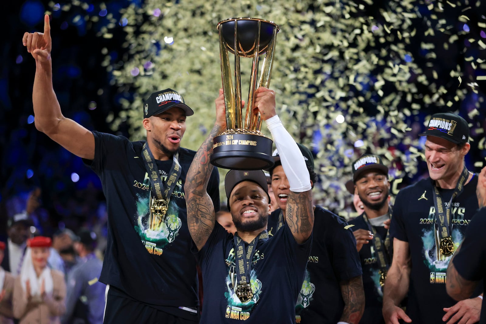 Milwaukee Bucks guard Damian Lillard (0) lifts up the NBA Cup while forward Giannis Antetokounmpo (34), left, and center Brook Lopez (11), right, celebrate after their team's victory in the championship game of the NBA Cup basketball tournament against the Oklahoma City Thunder Tuesday, Dec. 17, 2024, in Las Vegas. (AP Photo/Ian Maule)