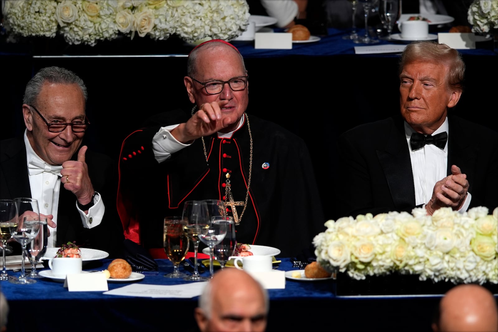 Senate Majority Leader Chuck Schumer of N.Y., and Cardinal Timothy Dolan gesture as Republican presidential nominee former President Donald Trump watches at the 79th annual Alfred E. Smith Memorial Foundation Dinner, Thursday, Oct. 17, 2024, in New York. (AP Photo/Julia Demaree Nikhinson)