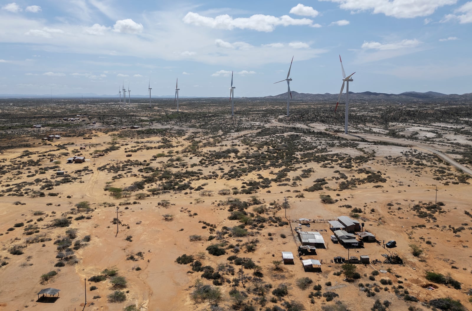 Wind turbines operate near rancherias, thatched-like roofed huts, on the outskirts of Cabo de la Vela, Colombia, Friday, Feb. 7, 2025. (AP Photo/Ivan Valencia)