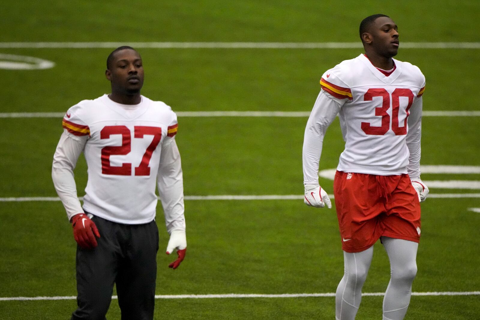 Kansas City Chiefs safety Chamarri Conner (27) and cornerback Christian Roland-Wallace (30) stretch during NFL football practice, Thursday, Jan. 30, 2025, in Kansas City, Mo. (AP Photo/Charlie Riedel)