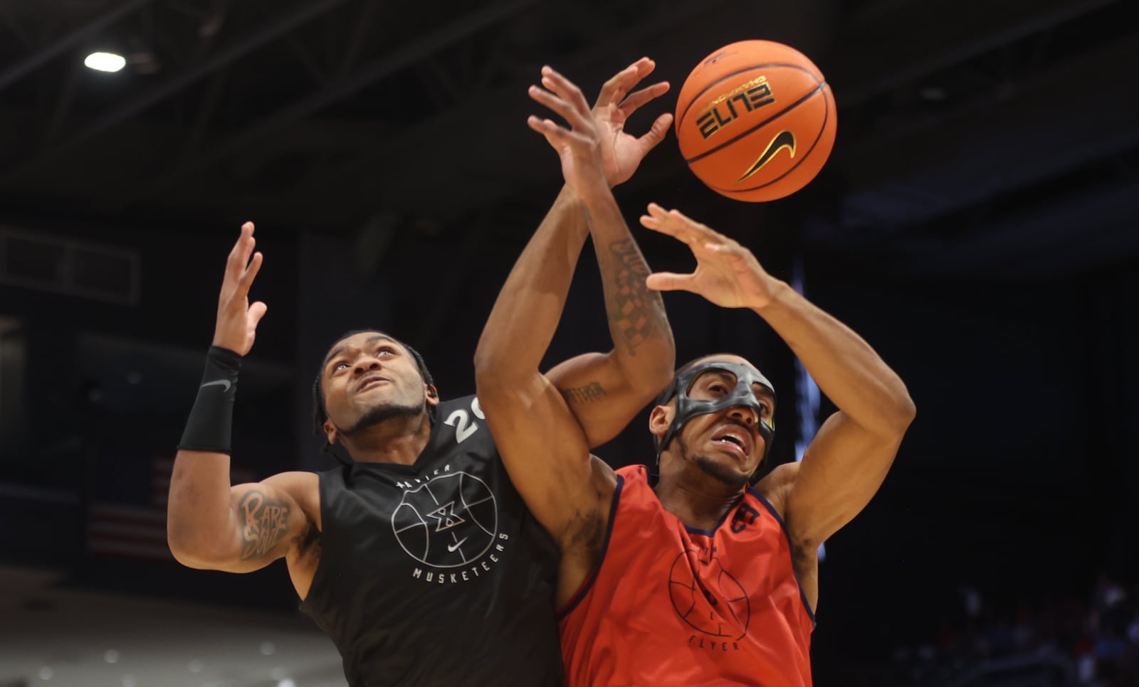 Dayton's Zed Key, right, and Xavier's Dayvion McKnight compete for a rebound in an exhibition game on Sunday, Oct. 20, 2024, at UD Arena. David Jablonski/Staff