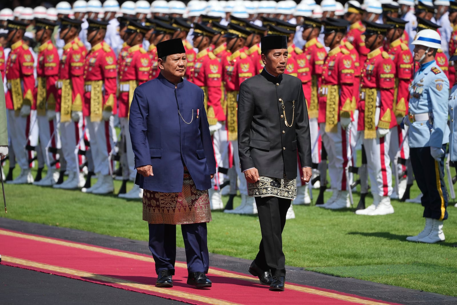 Indonesia's newly-inaugurated President Prabowo Subianto, left, and his predecessor Joko Widodo inspect honor guards during their handover ceremony at Merdeka Palace in Jakarta, Indonesia, Sunday, Oct. 20, 2024. (AP Photo/Achmad Ibrahim)