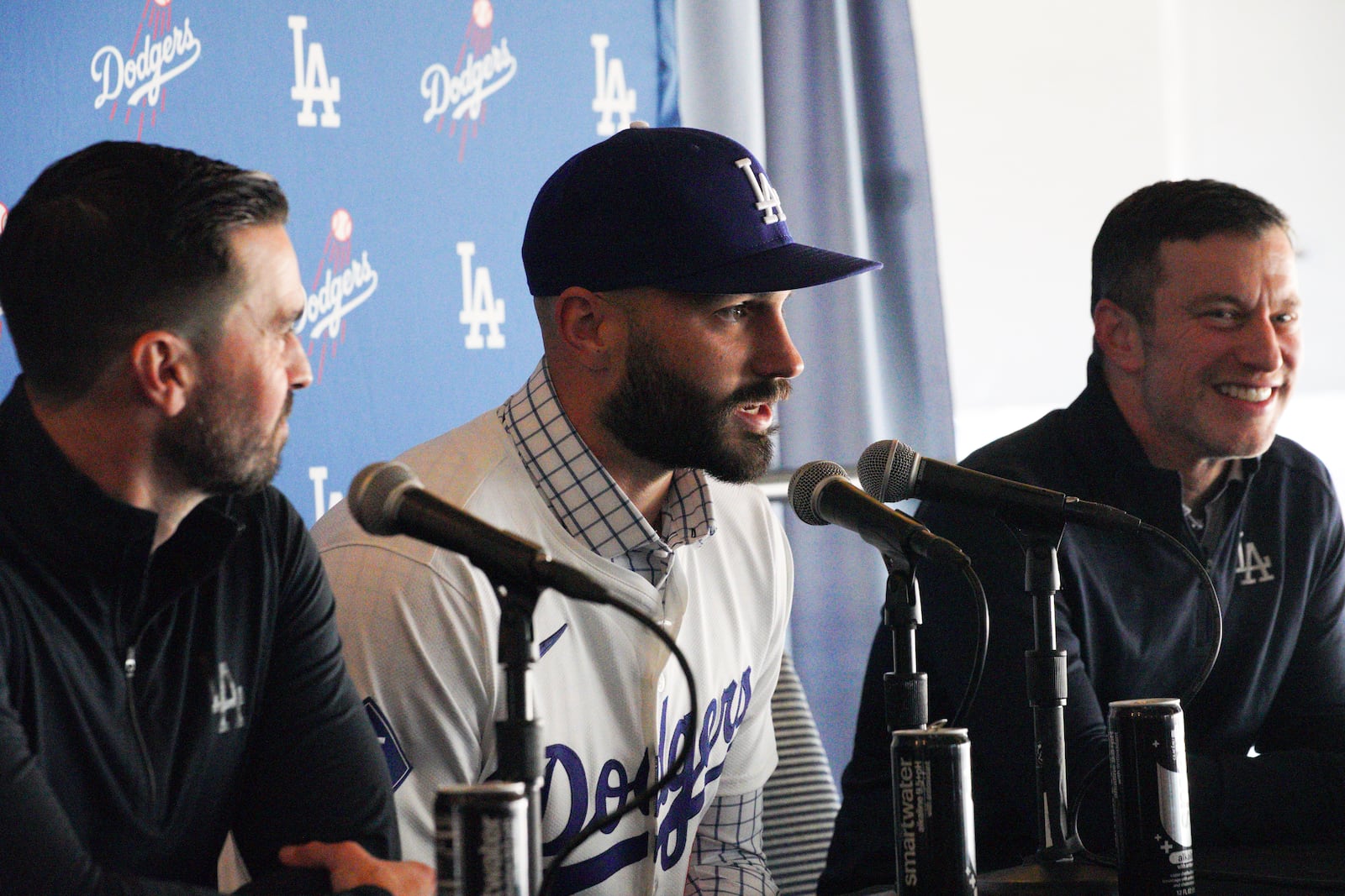 Left-handed reliever Tanner Scott, center, answers questions while flanked by Andrew Friedman, right, president of baseball operations for the Los Angeles Dodgers, and Brandan Gomes, left, Dodgers executive vice president and general manager, during an introductory news conference at Dodger Stadium in Los Angeles, Thursday, Jan. 23, 2025. (AP Photo/Richard Vogel)