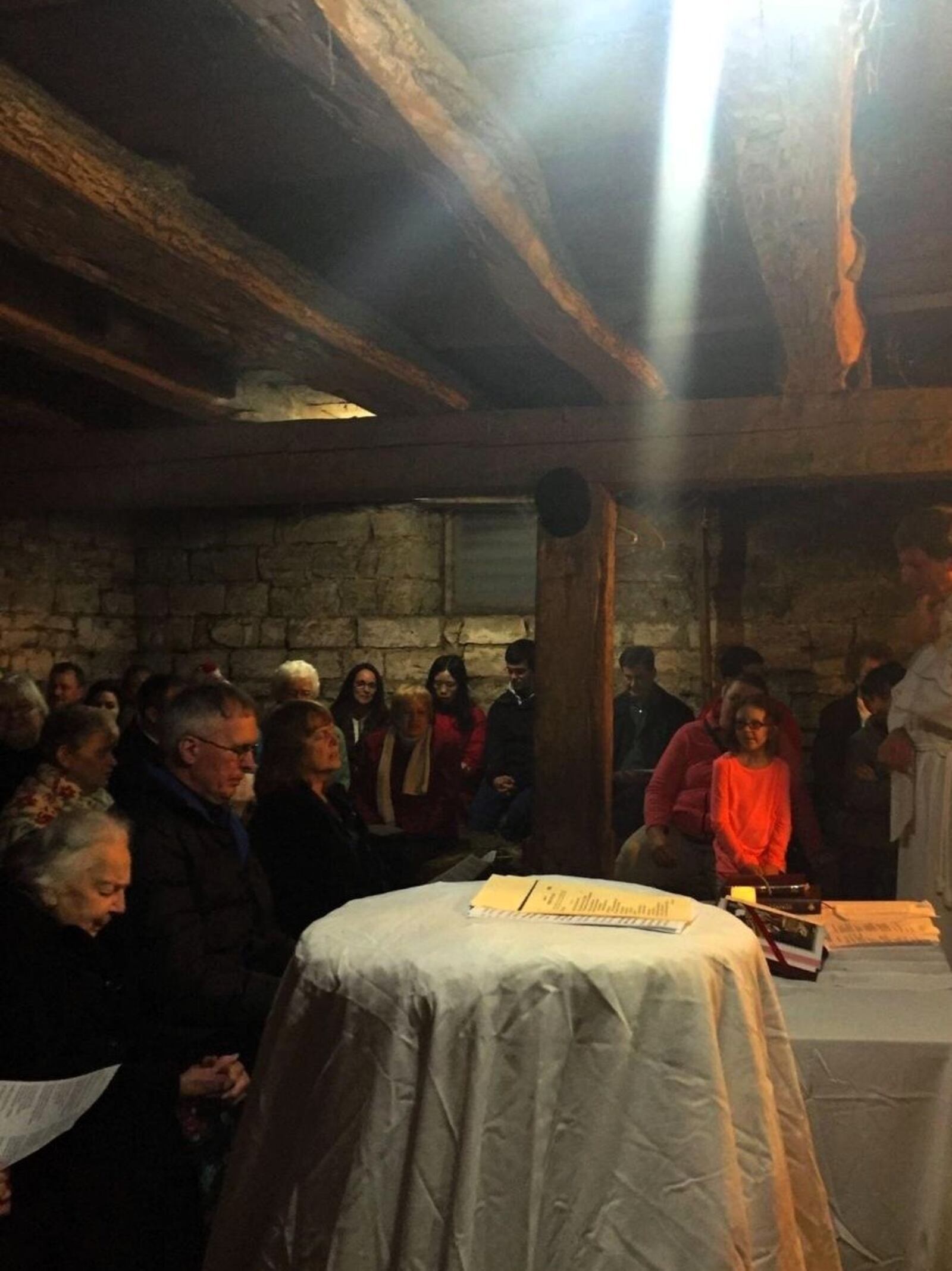 Light shines down from above during the Christmas Eve celebration in the Westendorf’s 168-year-old barn. Family members and a few friends sit on hay bales. CONTRIBUTED