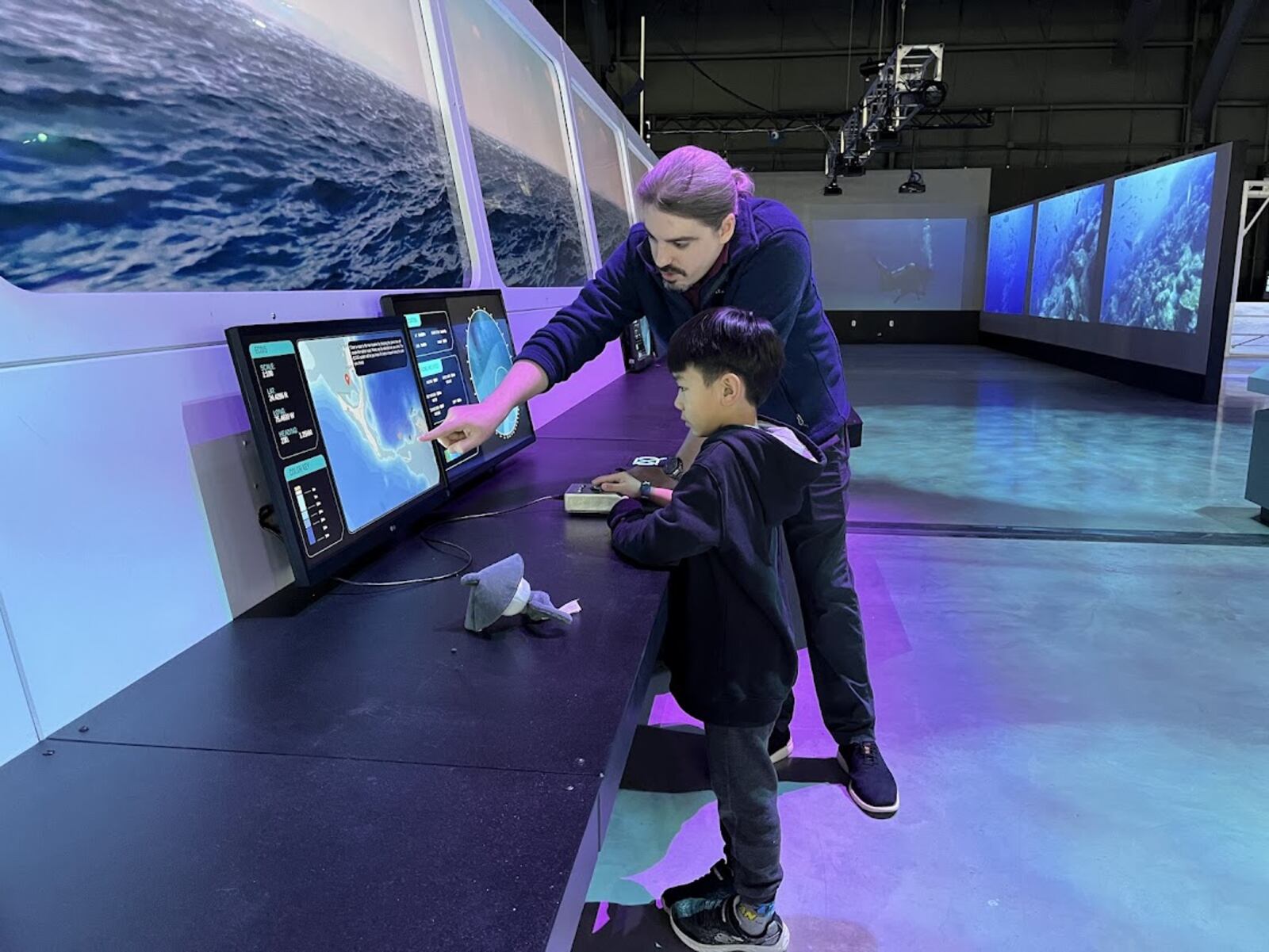 Bill Horner, attractions manager for the Air Force Museum Foundation, shows a young guest Tuesday Feb. 4, 2025 part of the museum's new (but temporary) OceanXperience exhibit. THOMAS GNAU/STAFF