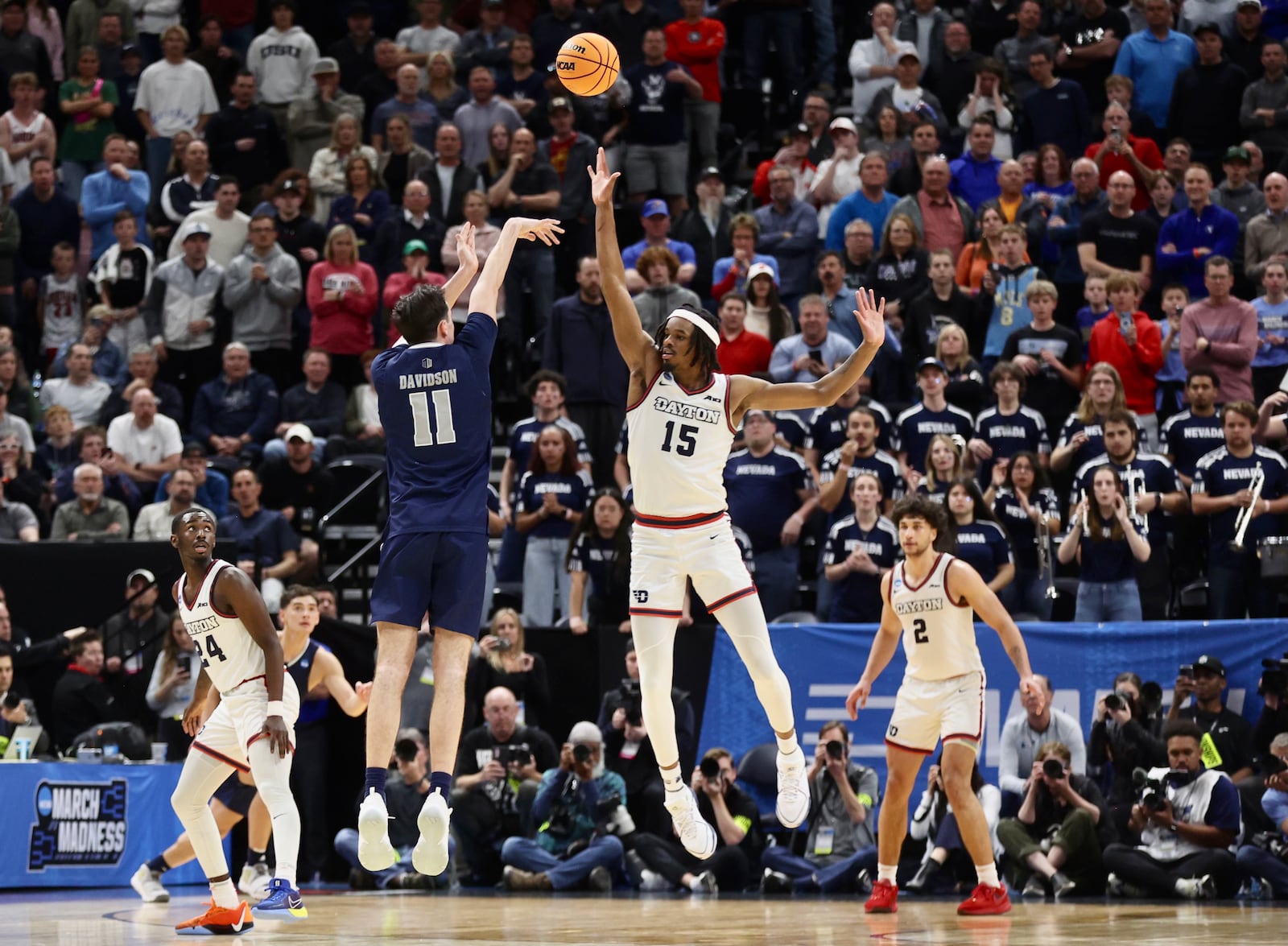 Dayton's DaRon Holmes II, right, defends a 3-pointer attempt by Nevada's Nick Davidson in the final seconds of the game in the first round of the NCAA tournament on Thursday, March 21, 2024, at the Delta Center in Salt Lake City, Utah. David Jablonski/Staff