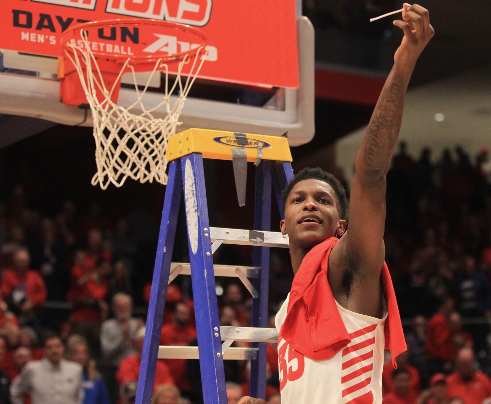 Dayton’s Dwayne Cohill cuts off a piece of the net after a victory against George Washington on March 7, 2020, at UD Arena. David Jablonski/Staff