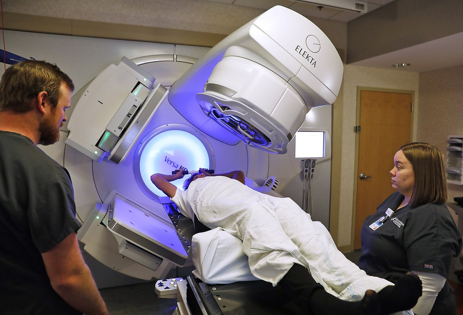 Wes England and Kim Spriggs, radiation theropists at Springfield Regional Cancer Center, demonstrate how the new Versa HD radiation machine works Wednesday. The machine is much more accurate and is able to use higher doses of radiation to quicken the patients time in theropy. Bill Lackey/Staff