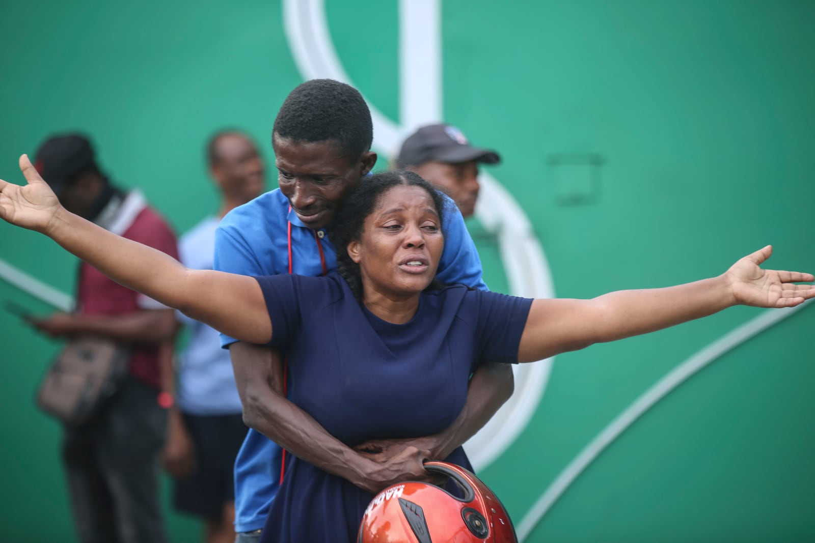 The wife of a journalist, who was shot during an armed gang attack on the General Hospital, cries as an ambulance arrives with his body, at a different hospital in Port-au-Prince, Haiti, Tuesday, Dec. 24, 2024. (AP Photo/Odelyn Joseph)