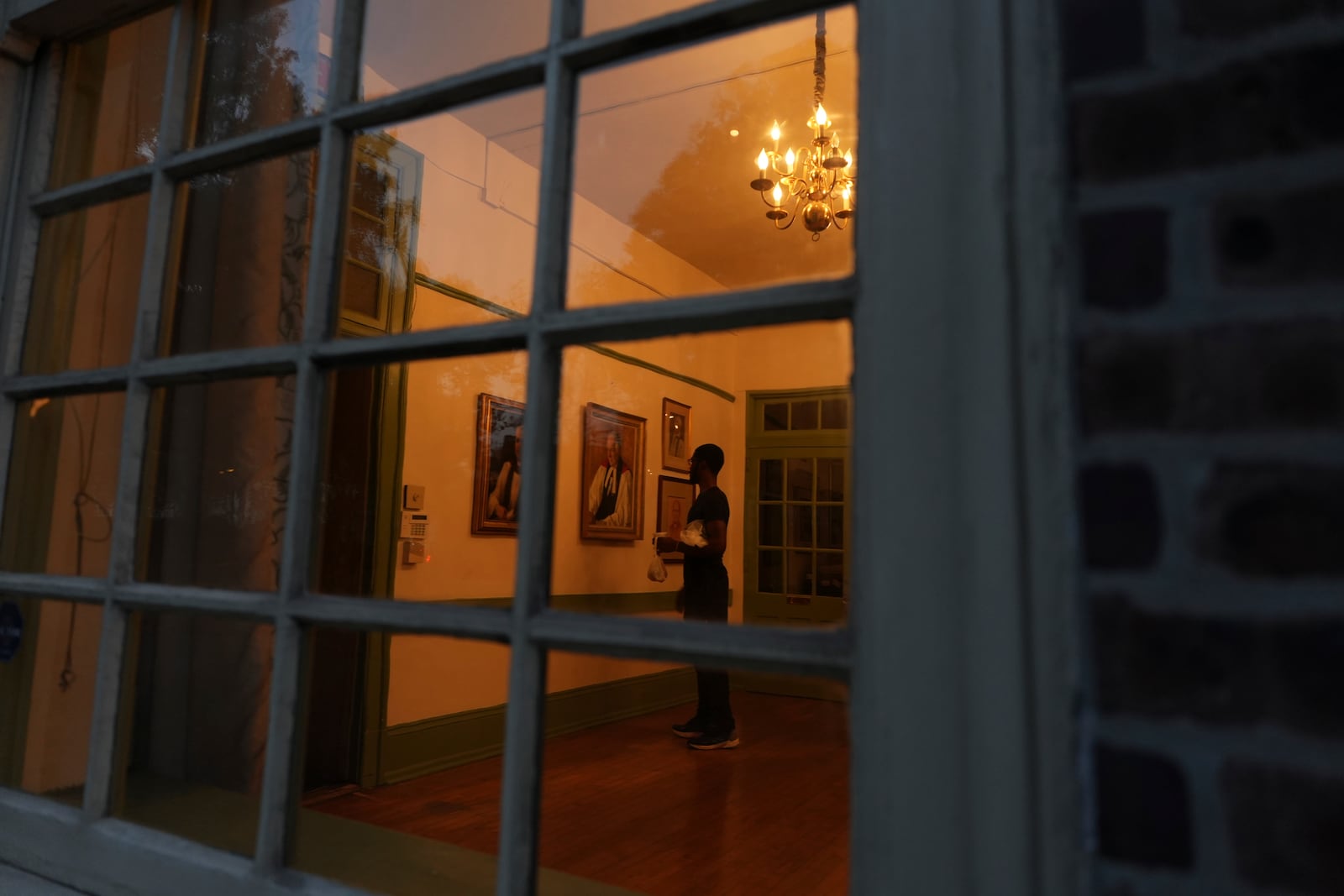 A member of Christ Church looks at portraits on display at the church Neighborhood House in Philadelphia on Sunday, Oct. 6, 2024. (AP Photo/Luis Andres Henao)