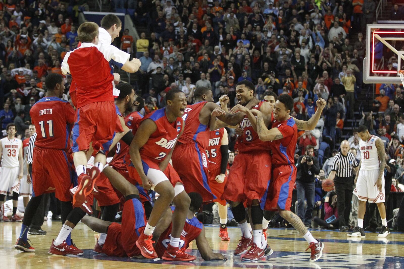 Dayton players celebrate after a 60-59 victory against Ohio State in the second round of the NCAA tournament on Thursday, March 20, 2014, at the First Niagara Center in Buffalo, N.Y. David Jablonski/Staff