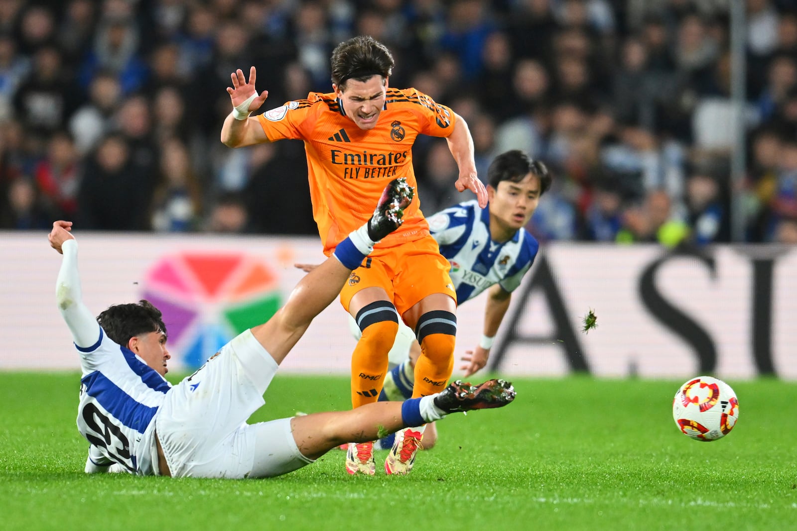 Real Madrid's Fran Garcia, centre, challenges for the ball with Real Sociedad's Jon Aramburu, left, during the Spanish Copa del Rey soccer match between Real Sociedad and Real Madrid at the Reale Arena in San Sebastian, Spain, Wednesday, Feb. 26, 2025. (AP Photo/Miguel Oses)