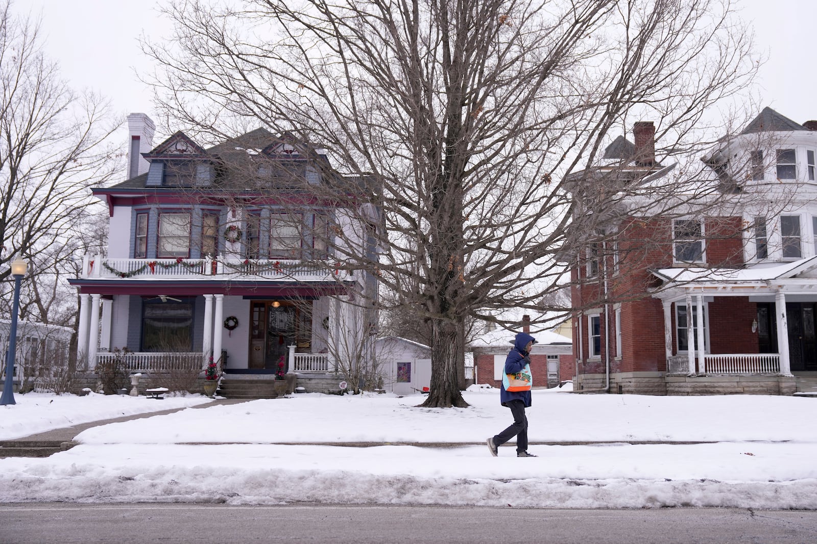 A Middletown resident walks through snow, Tuesday, Jan. 14, 2025, in Middletown, Ohio. The city is the hometown of Vice President-elect JD Vance.(AP Photo/Kareem Elgazzar)