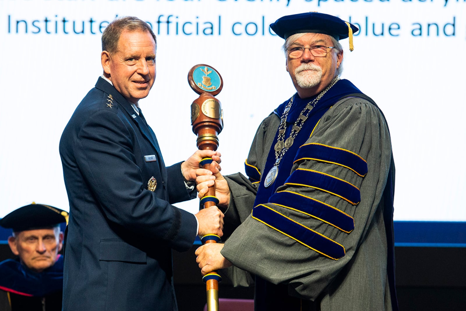 Lt. Gen. James Hecker, Air University commander and president, passes the Air Force Institute of Technology mace to Walter Jones as he accepts the role of director and chancellor during a ceremony July 27 at Wright-Patterson Air Force Base. Jones is the 50th AFIT leader and only the second civilian. U.S. AIR FORCE PHOTO/WESLEY FARNSWORTH