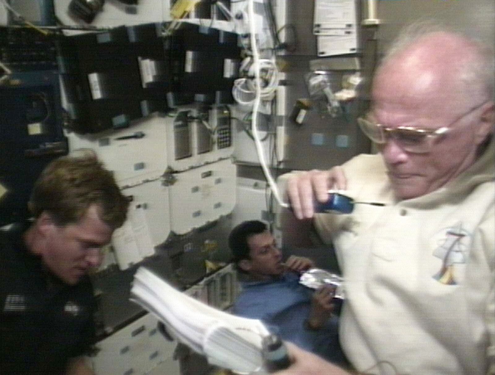 In a Saturday, Oct. 31, 1998, image from television, U.S. Senator John Glenn, right, speaks to mission control during an experiment aboard the Space Shuttle Discovery. (AP Photo/NASATV, File)