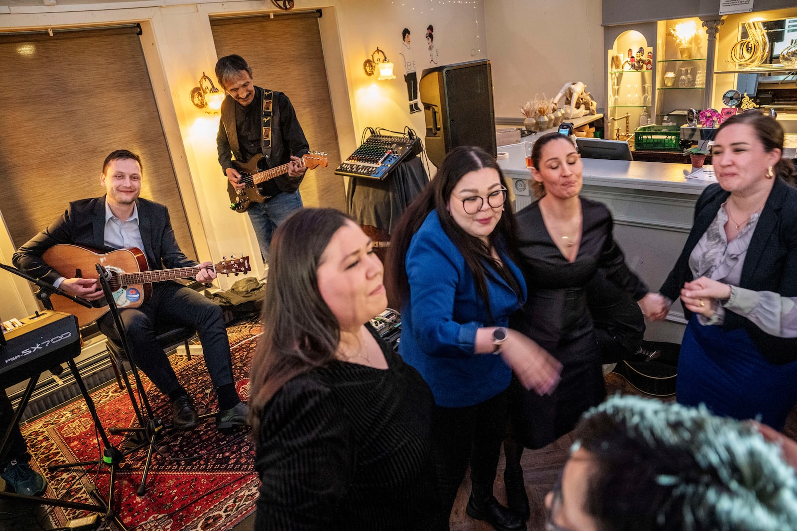 Chairman of Demokraatit, Jens-Frederik Nielsen, left, plays guitar as he celebrates during the election party at Demokraatit by cafe Killut in Nuuk, early Wednesday, March 12, 2025. (Mads Claus Rasmussen/Ritzau Scanpix via AP)