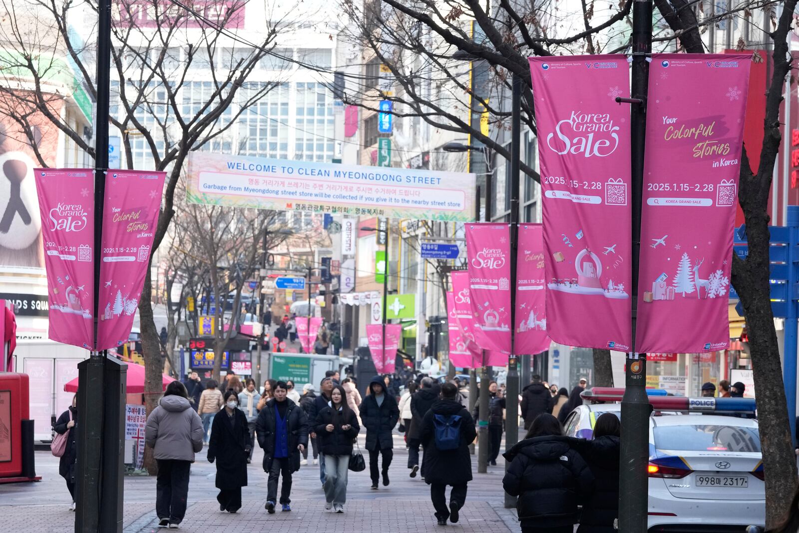 People walk on a shopping street in Seoul, South Korea, Tuesday, Feb. 11, 2025. (AP Photo/Ahn Young-joon)