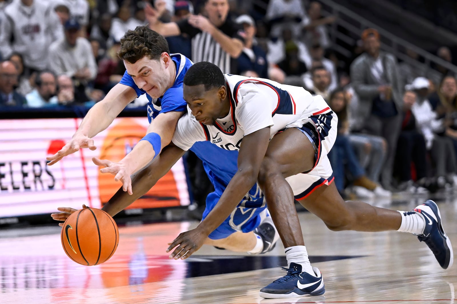 Creighton center Ryan Kalkbrenner, left, and UConn guard Hassan Diarra dive for the ball during the first half of an NCAA college basketball game, Saturday, Jan. 18, 2025, in Storrs, Conn. (AP Photo/Jessica Hill)