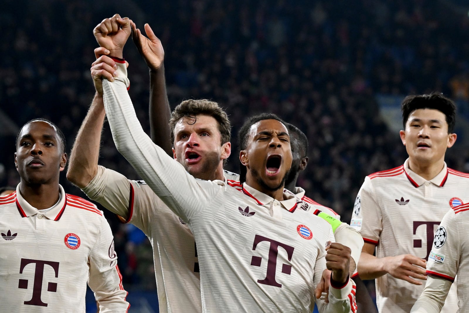 Bayern's Michael Olise, centre, celebrates after scoring his side's third goal with Thomas Muller, centre left, during the Champions League opening phase soccer match between Shakhtar Donetsk and Bayern Munich at the Veltins Arena in Gelsenkirchen, Germany, Tuesday, Dec. 10, 2024. (David Inderlied/dpa via AP)