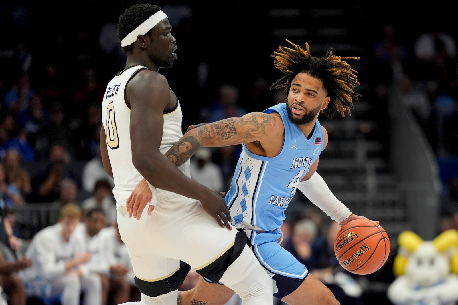 North Carolina guard RJ Davis drives to the basket past Wake Forest forward Omaha Biliew during the first half of an NCAA college basketball game in the quarterfinals of the Atlantic Coast Conference tournament, Thursday, March 13, 2025, in Charlotte, N.C. (AP Photo/Chris Carlson)