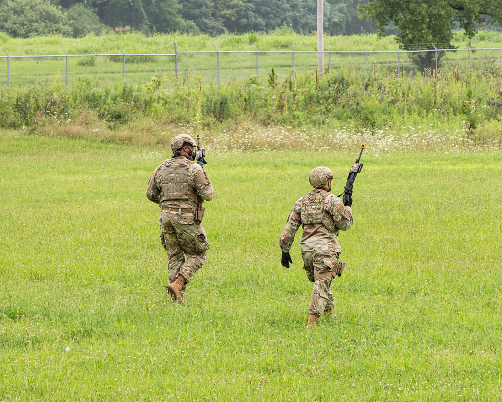 Two Defenders from the 88th Security Forces Squadron patrol a field during an active-shooter exercise Aug. 10 at Wright-Patterson Air Force Base. The exercise was conducted to test the skills of first responders in a potential real-world scenario. U.S. AIR FORCE PHOTO/JAIMA FOGG