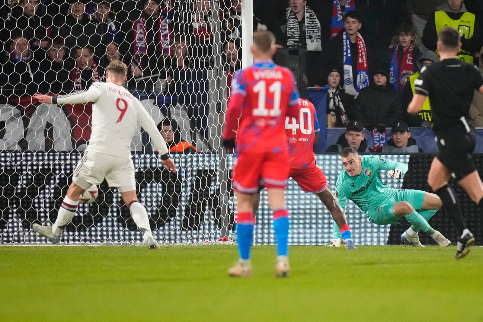 Manchester United's Rasmus Hojlund, left, scores his side's opening goal during the Europa League soccer match between Viktoria Plzen and Manchester United at the Doosan Arena in Plzen, Czech Republic, Thursday, Dec. 12, 2024. (AP Photo/Petr David Josek)