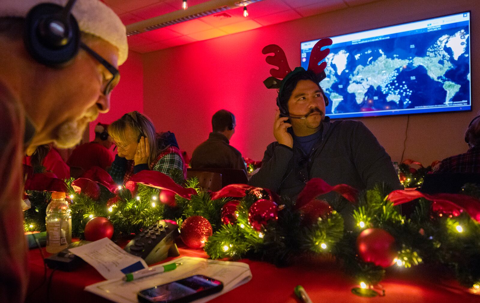 Volunteers answer phone calls from around the world Tuesday, Dec. 24, 2024, at the NORAD Tracks Santa center at Peterson Space Force Base in Colorado Springs, Colo. (Christian Murdock /The Gazette via AP)