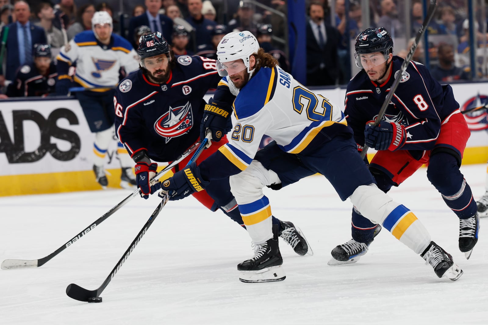 St. Louis Blues' Brandon Saad, center, carries the puck between Columbus Blue Jackets' Kirill Marchenko, left, and Zach Werenski during the first period of an NHL hockey game Saturday, Jan. 4, 2025, in Columbus, Ohio. (AP Photo/Jay LaPrete)