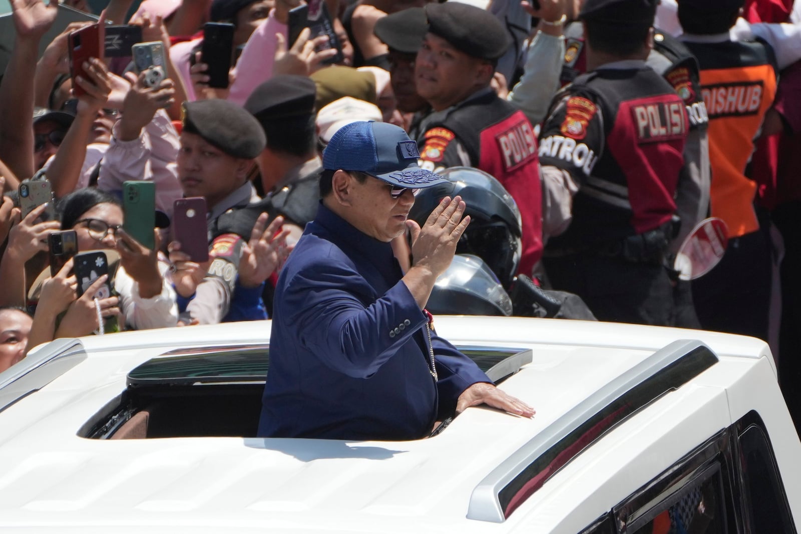 Newly-inaugurated Indonesian President Prabowo Subianto, center, salutes as he greets supporters after being sworn in as the country's eighth president in Jakarta, Indonesia, Sunday, Oct. 20, 2024. (AP Photo/Dita Alangkara)